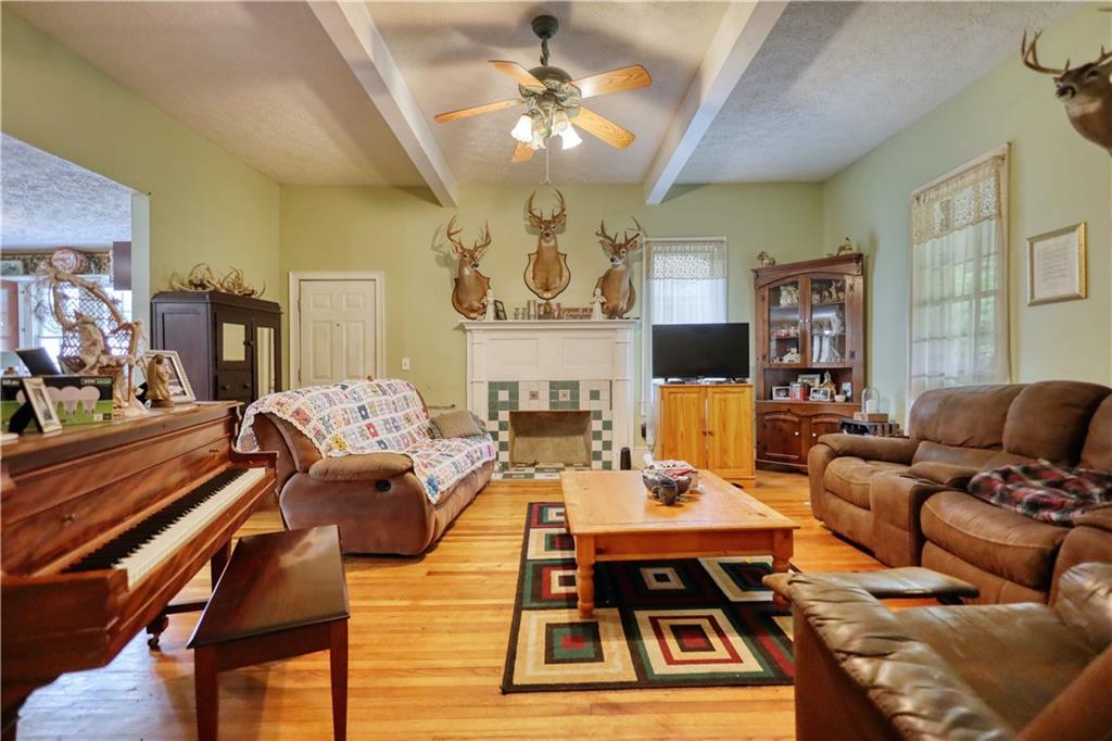 5011 Penfield Road Union Point, GA 30669 - Photo 10 of 68 a living room with fireplace furniture and a chandelier