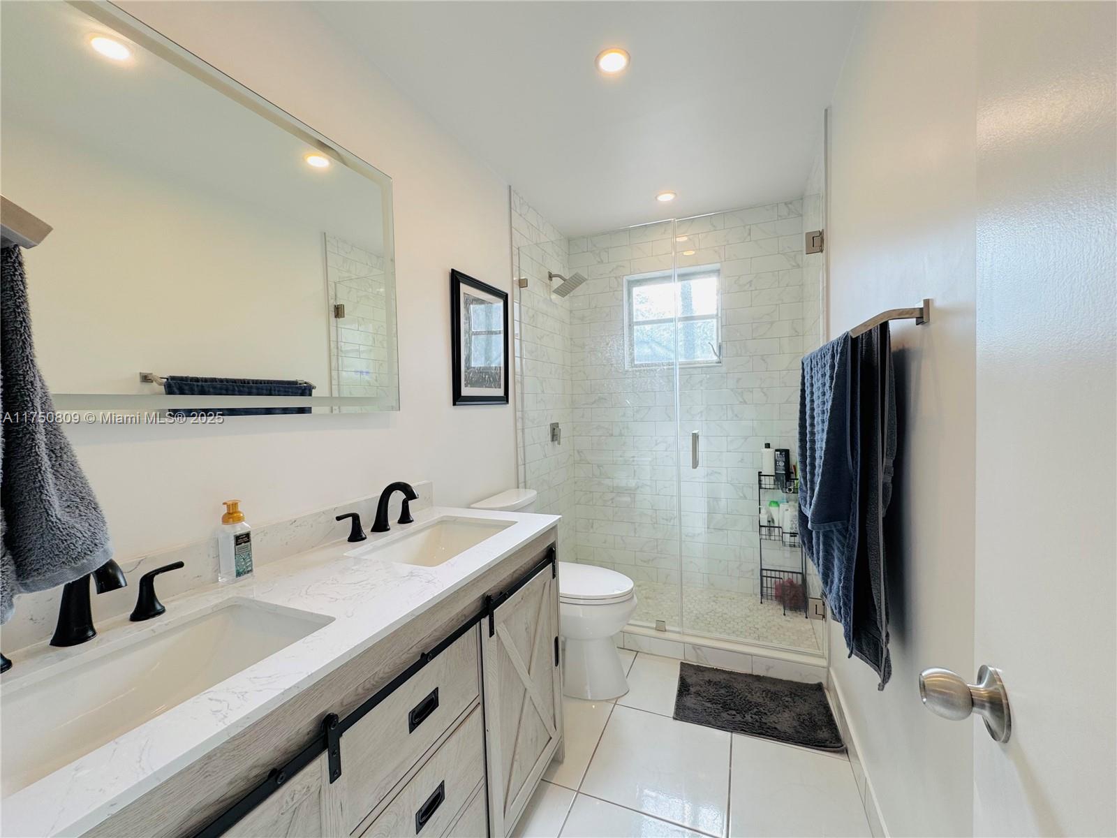 9394 Southwest 77th Avenue, Unit F1 Miami, FL 33156 - Photo 11 of 24 a bathroom with a sink toilet and shower