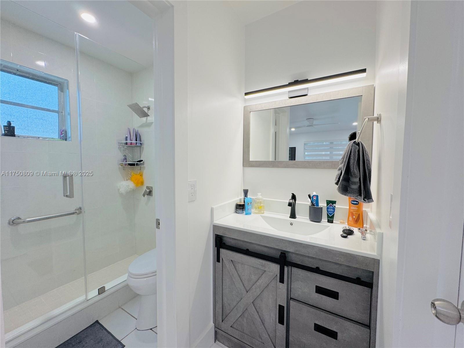 9394 Southwest 77th Avenue, Unit F1 Miami, FL 33156 - Photo 13 of 24 a bathroom with a sink and a mirror