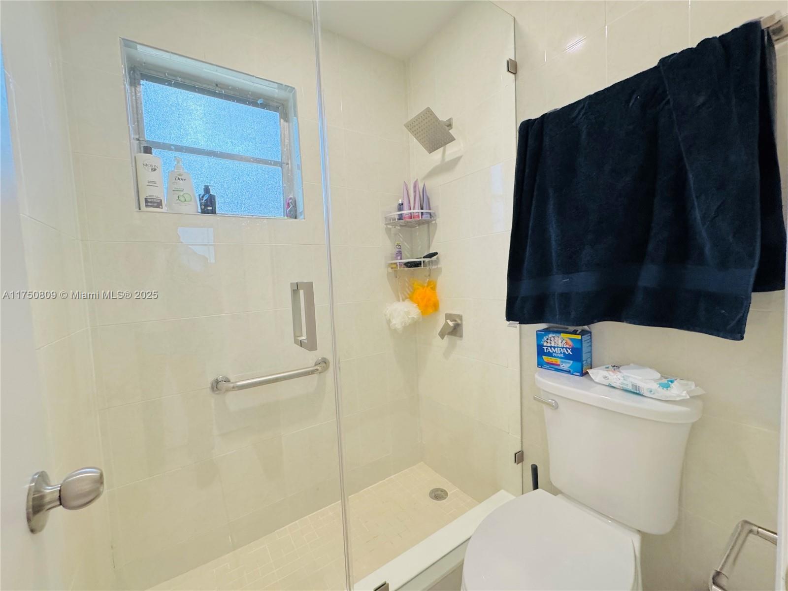 9394 Southwest 77th Avenue, Unit F1 Miami, FL 33156 - Photo 14 of 24 a bathroom with a sink a toilet and shower