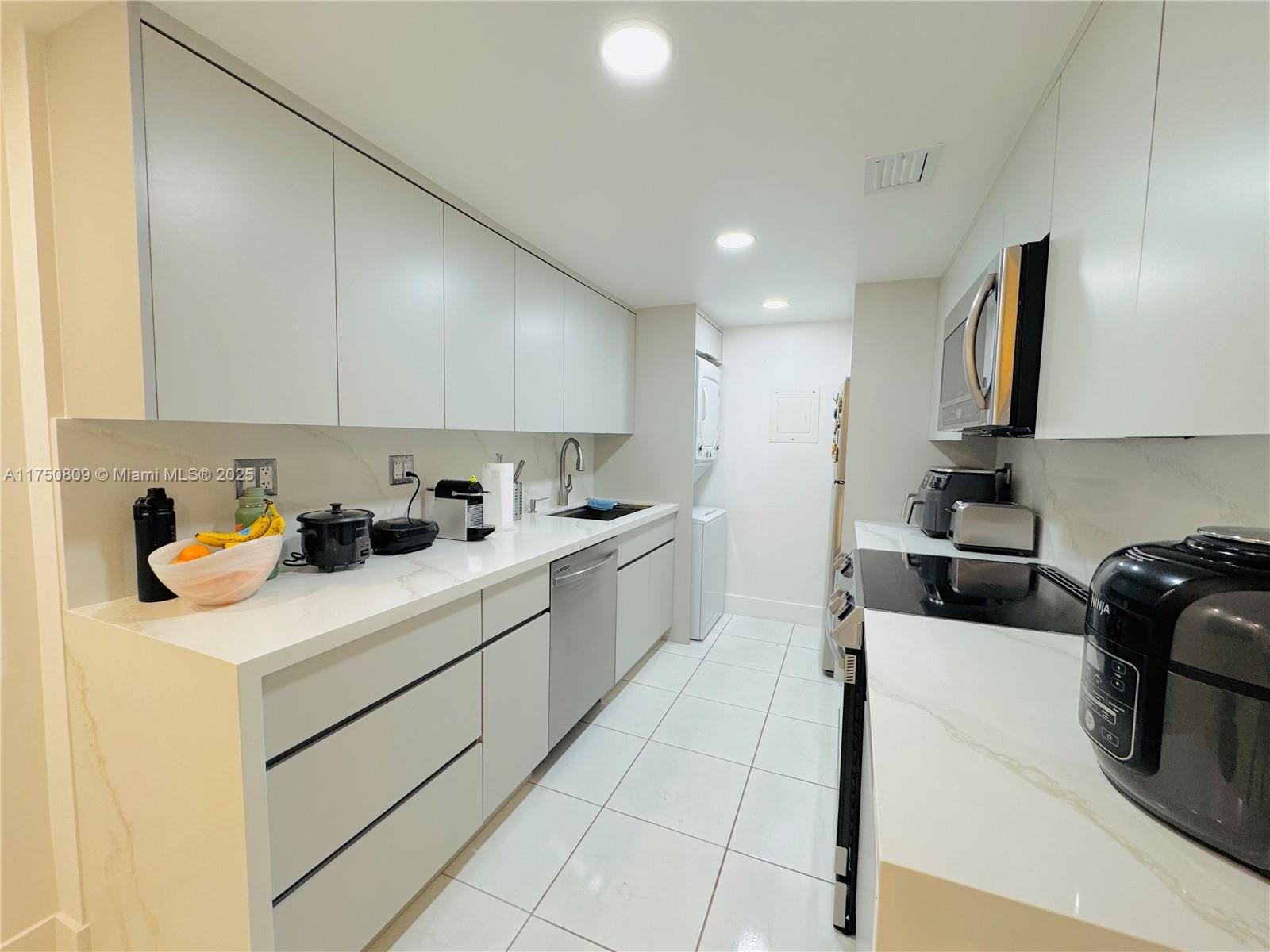 9394 Southwest 77th Avenue, Unit F1 Miami, FL 33156 - Photo 4 of 24 a kitchen that has a sink and a stove in it