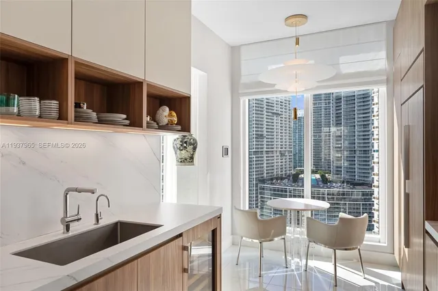 a view of a dining room with furniture a chandelier and large windows