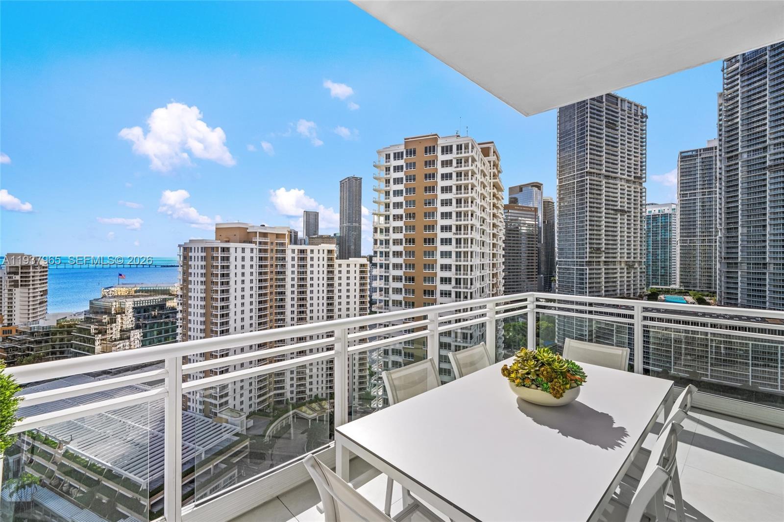 900 Brickell Key Boulevard, Unit 2004 Miami, FL 33131 - Photo 16 of 35 a view of a balcony dining table and chairs
