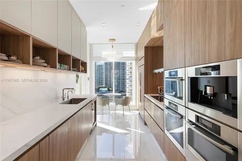 a kitchen with stainless steel appliances kitchen island granite countertop a refrigerator and a sink