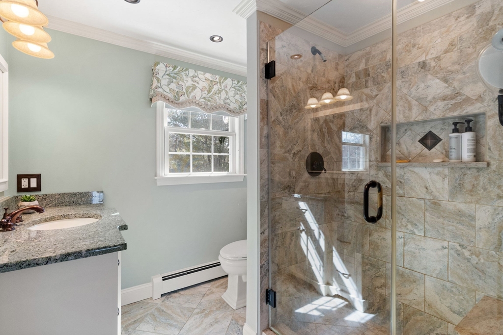 21 Worcester Road Norfolk, MA 02056 - Photo 23 of 40 a bathroom with a granite countertop sink a toilet a mirror and shower