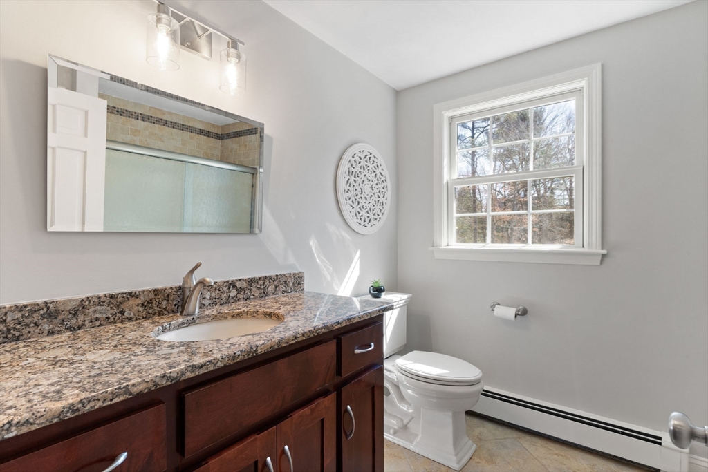 21 Worcester Road Norfolk, MA 02056 - Photo 24 of 40 a bathroom with a granite countertop toilet a sink and a mirror