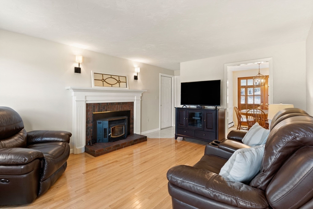 21 Worcester Road Norfolk, MA 02056 - Photo 5 of 40 a living room with furniture a flat screen tv and a fireplace