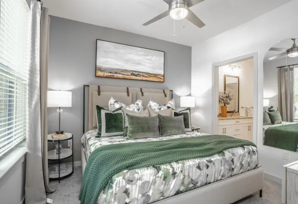 a bedroom with a bed mirror and window