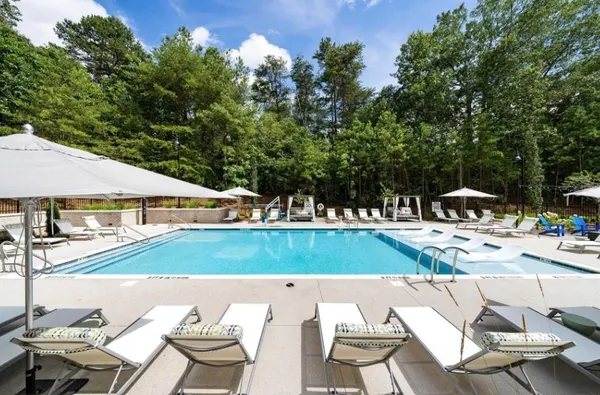 a view of a patio with table and chairs under an umbrella with wooden floor