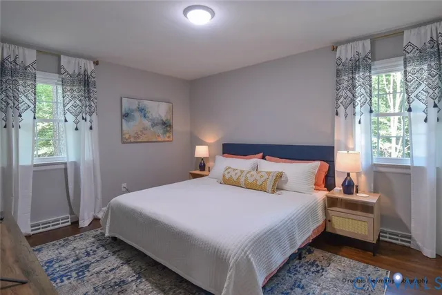 a bedroom with a bed wooden floor and window