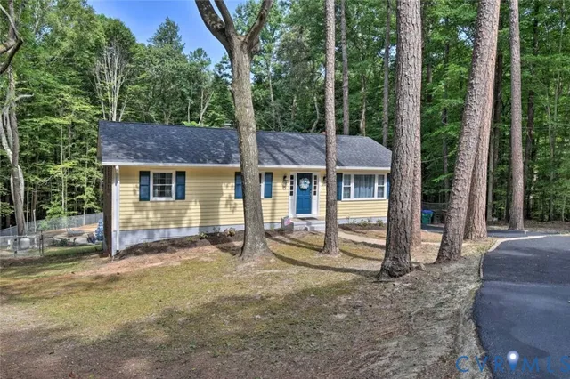 a view of a house with a yard and large tree