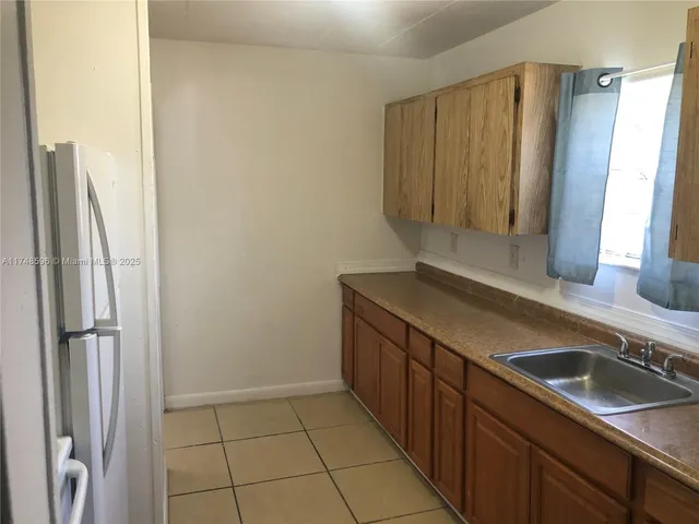 a kitchen with stainless steel appliances granite countertop a sink and a refrigerator