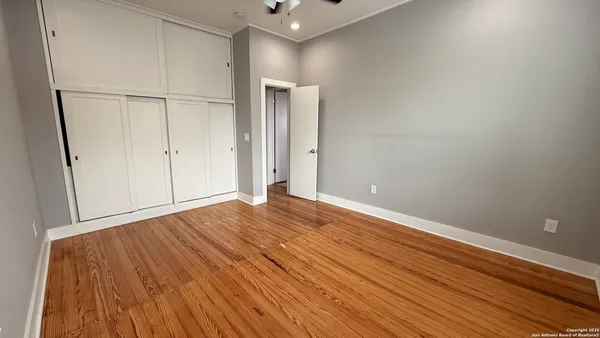 a view of empty room with wooden floor