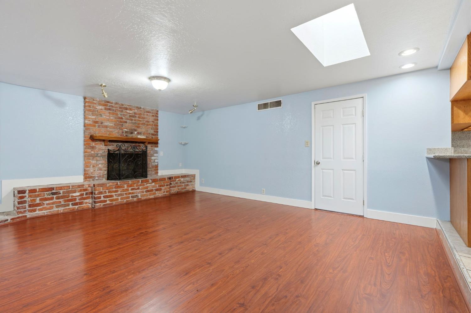 2826 East Hampton Way Fresno, CA 93726 - Photo 16 of 33 an empty room with wooden floor fireplace and windows