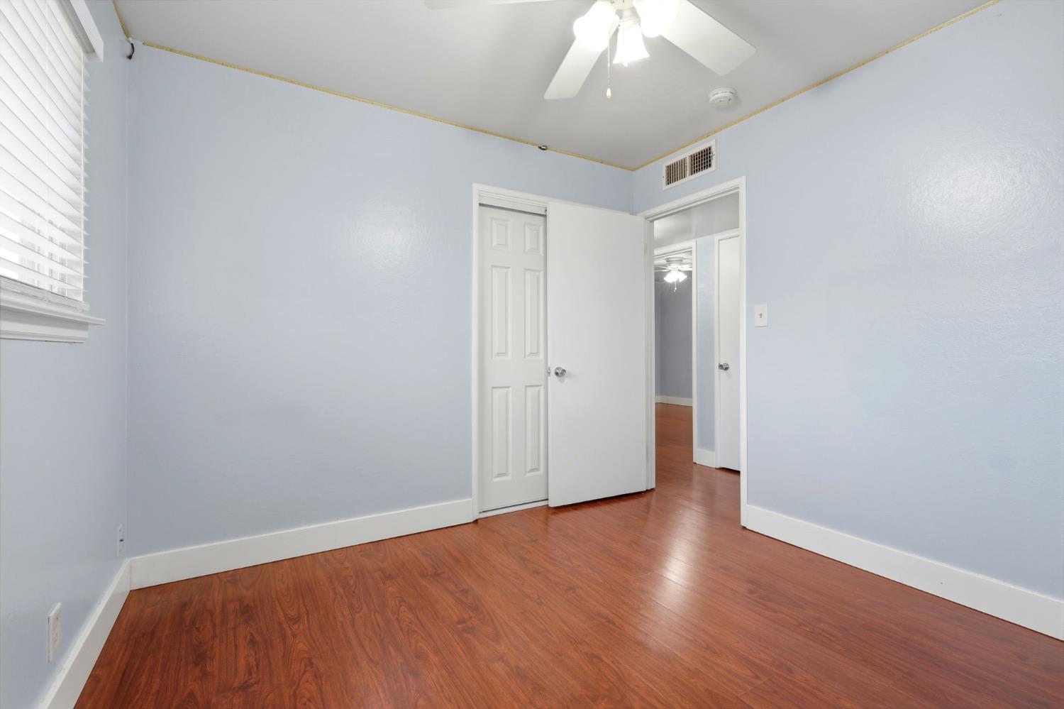 2826 East Hampton Way Fresno, CA 93726 - Photo 19 of 33 an empty room with wooden floor and windows