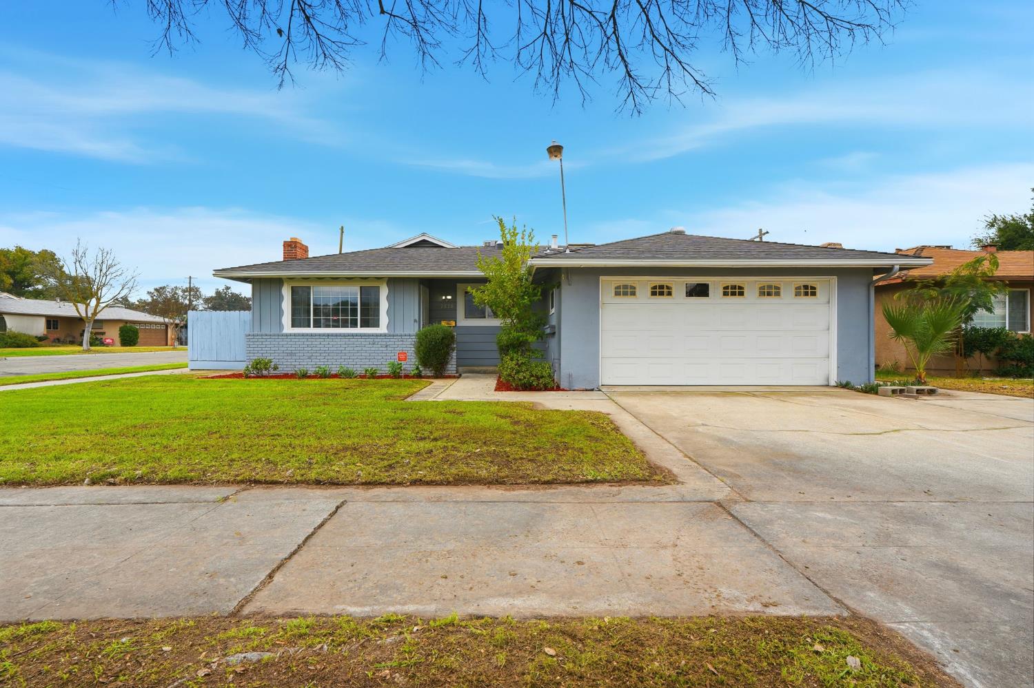2826 East Hampton Way Fresno, CA 93726 - Photo 2 of 33 a front view of a house with a yard and garage