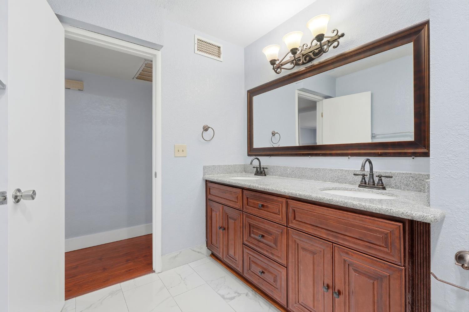 2826 East Hampton Way Fresno, CA 93726 - Photo 26 of 33 a bathroom with a double vanity sink and a mirror