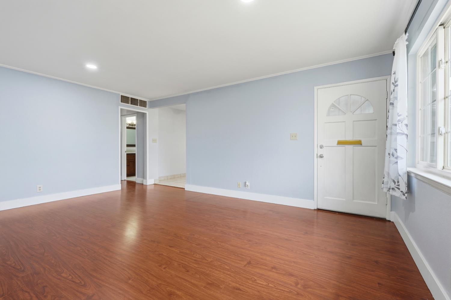 2826 East Hampton Way Fresno, CA 93726 - Photo 6 of 33 a view of an empty room with wooden floor and a window
