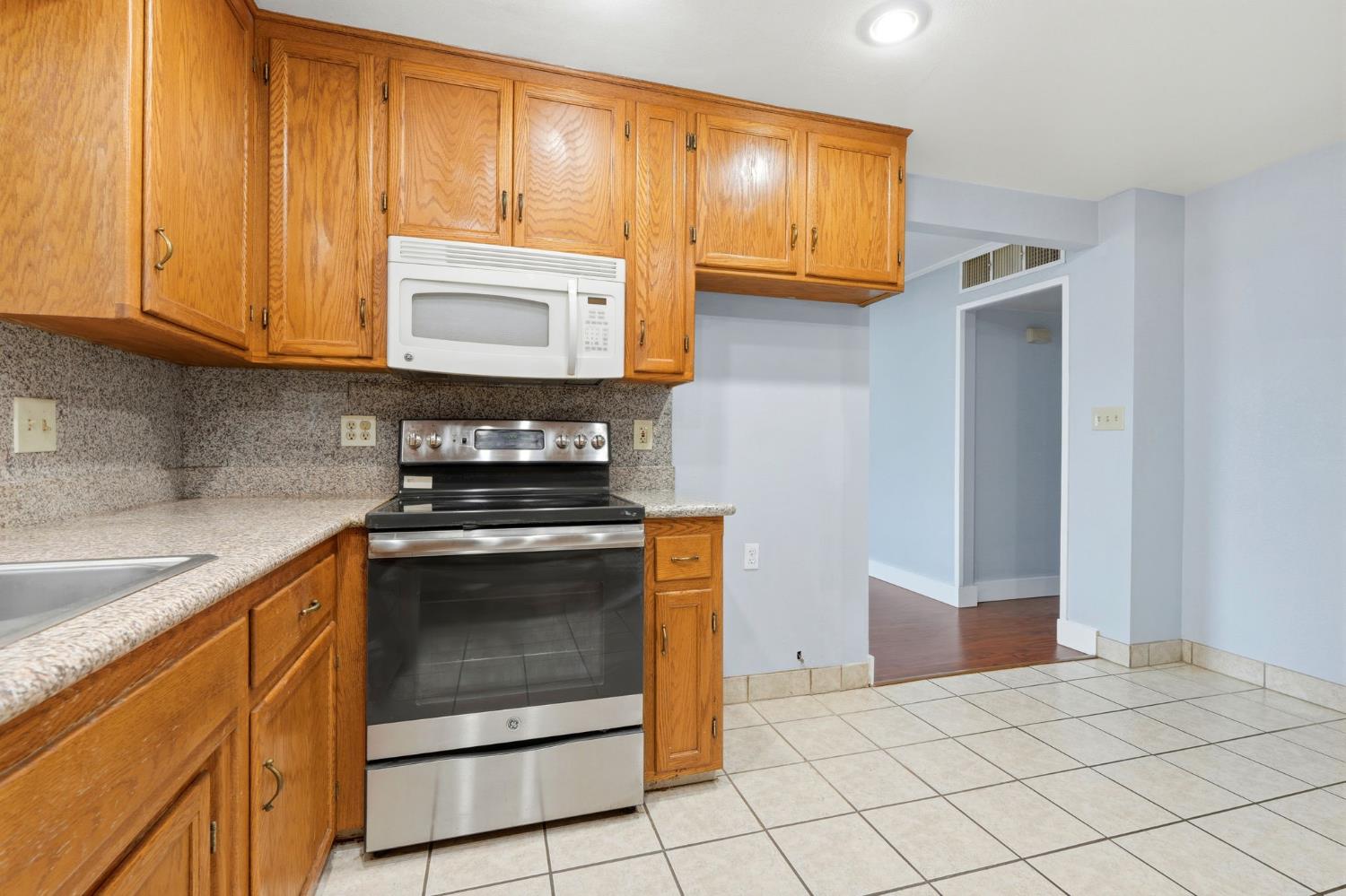 2826 East Hampton Way Fresno, CA 93726 - Photo 9 of 33 a kitchen with granite countertop cabinets stainless steel appliances and a sink