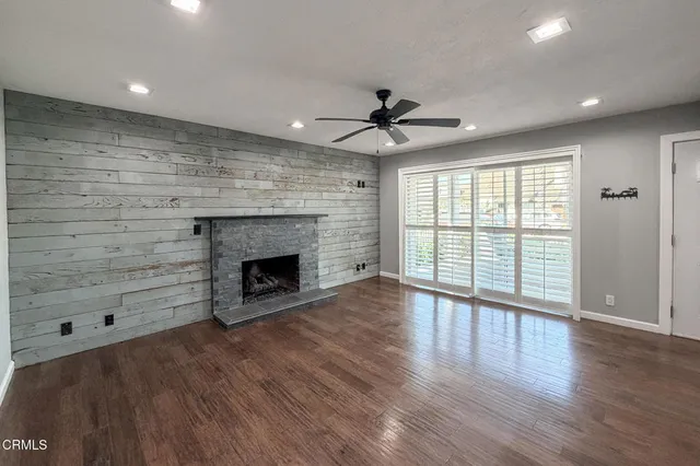 a view of an empty room with a fireplace and a window