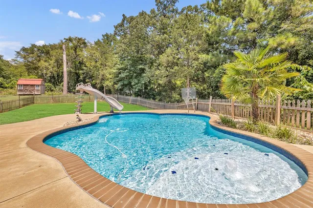 a view of a backyard with swimming pool