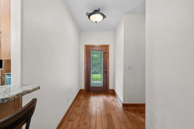 a view of a hallway with wooden floor and closet