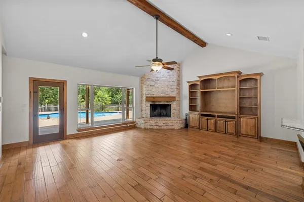 a view of empty room with wooden floor and fireplace