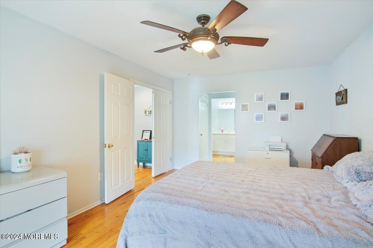 53 Racquet Road Wall, NJ 07719 - Photo 11 of 29 a bedroom with a large bed and a chandelier