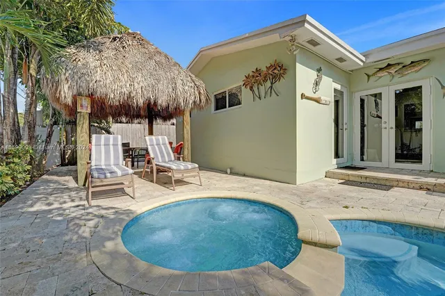 a living room with couches and kitchen view with wooden floor