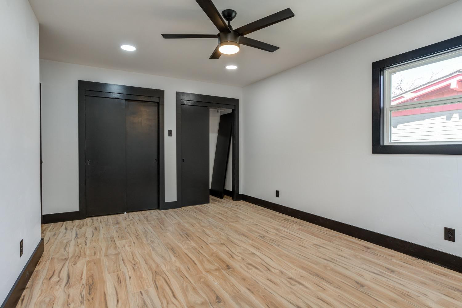 3410 40th Street Lubbock, TX 79413 - Photo 27 of 45 a view of a big room with wooden floor and a ceiling fan