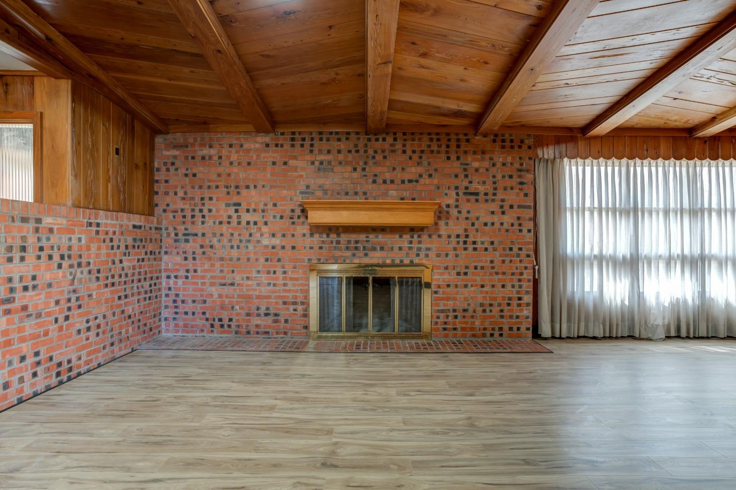 3410 40th Street Lubbock, TX 79413 - Photo 7 of 45 a view of an empty room with wooden floor and a fireplace