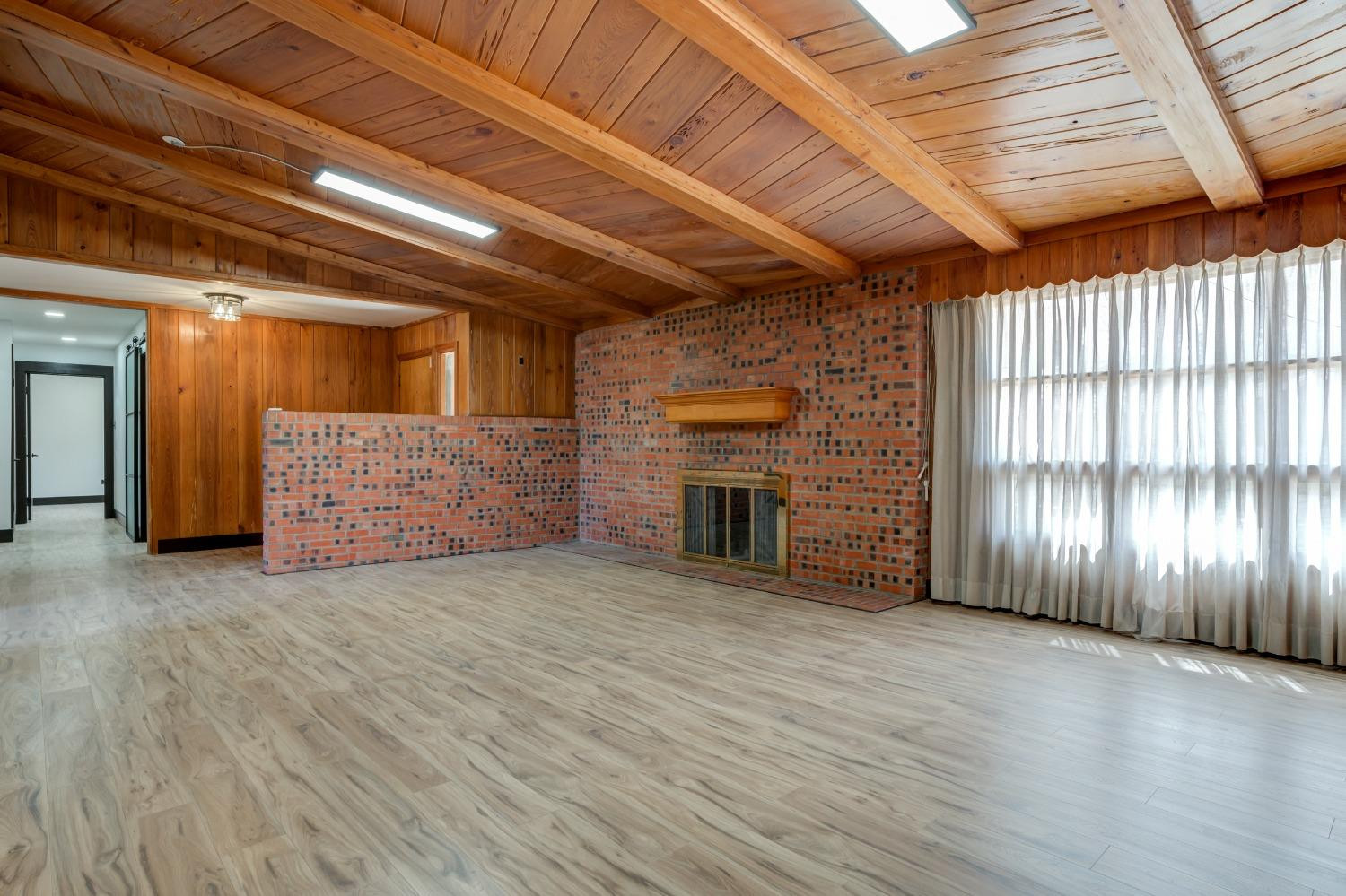 3410 40th Street Lubbock, TX 79413 - Photo 8 of 45 a view of an empty room with a fireplace and a window