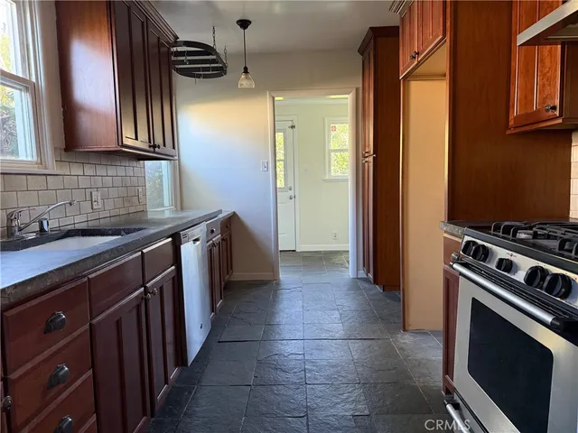 a kitchen with stainless steel appliances a stove sink and cabinets