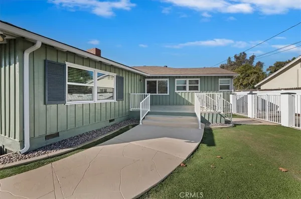 a front view of a house with a yard and seating space