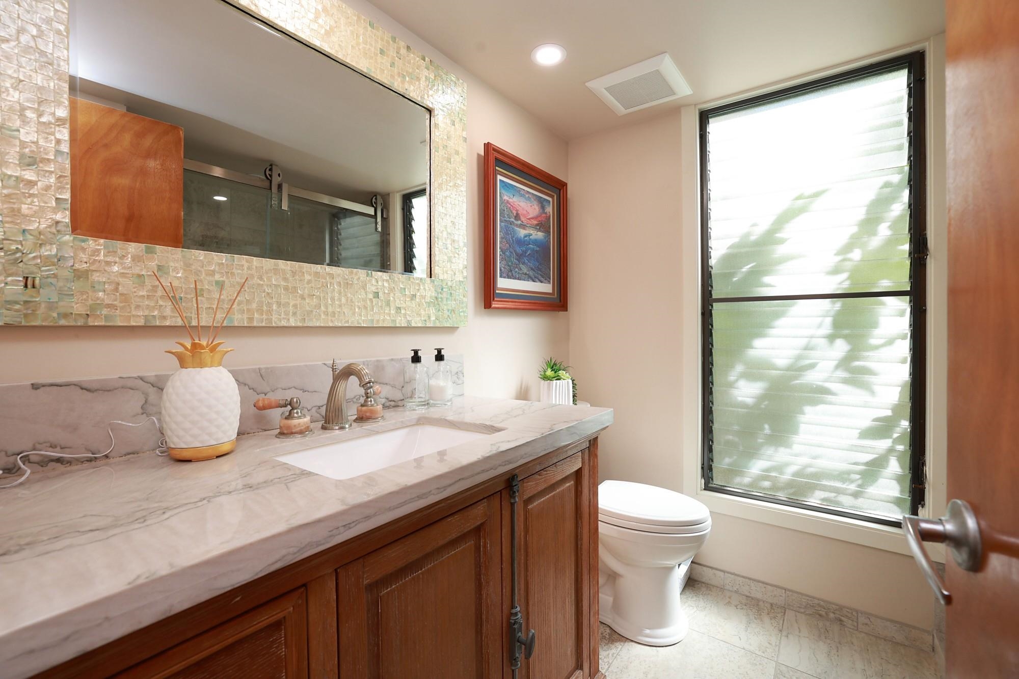 5045 Lower Honoapiilani Road, Unit 2 Lahaina, HI 96761 - Photo 12 of 37 a bathroom with a granite countertop sink toilet and mirror