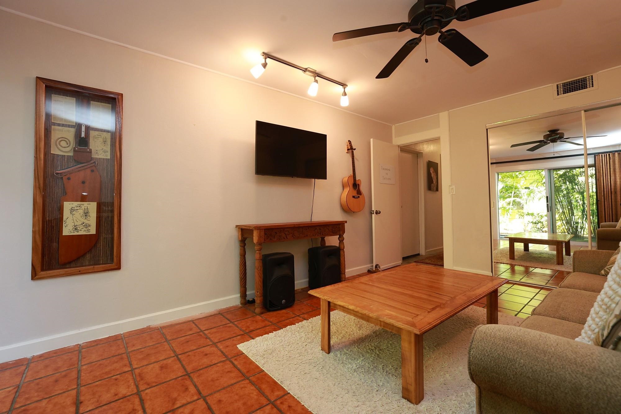 5045 Lower Honoapiilani Road, Unit 2 Lahaina, HI 96761 - Photo 32 of 37 a living room with furniture a fireplace and a flat screen tv