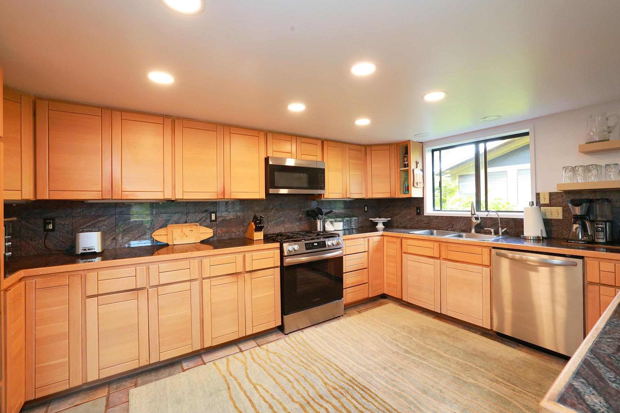 5045 Lower Honoapiilani Road, Unit 2 Lahaina, HI 96761 - Photo 5 of 37 a kitchen with stainless steel appliances granite countertop a stove a sink dishwasher and a refrigerator with wooden floor