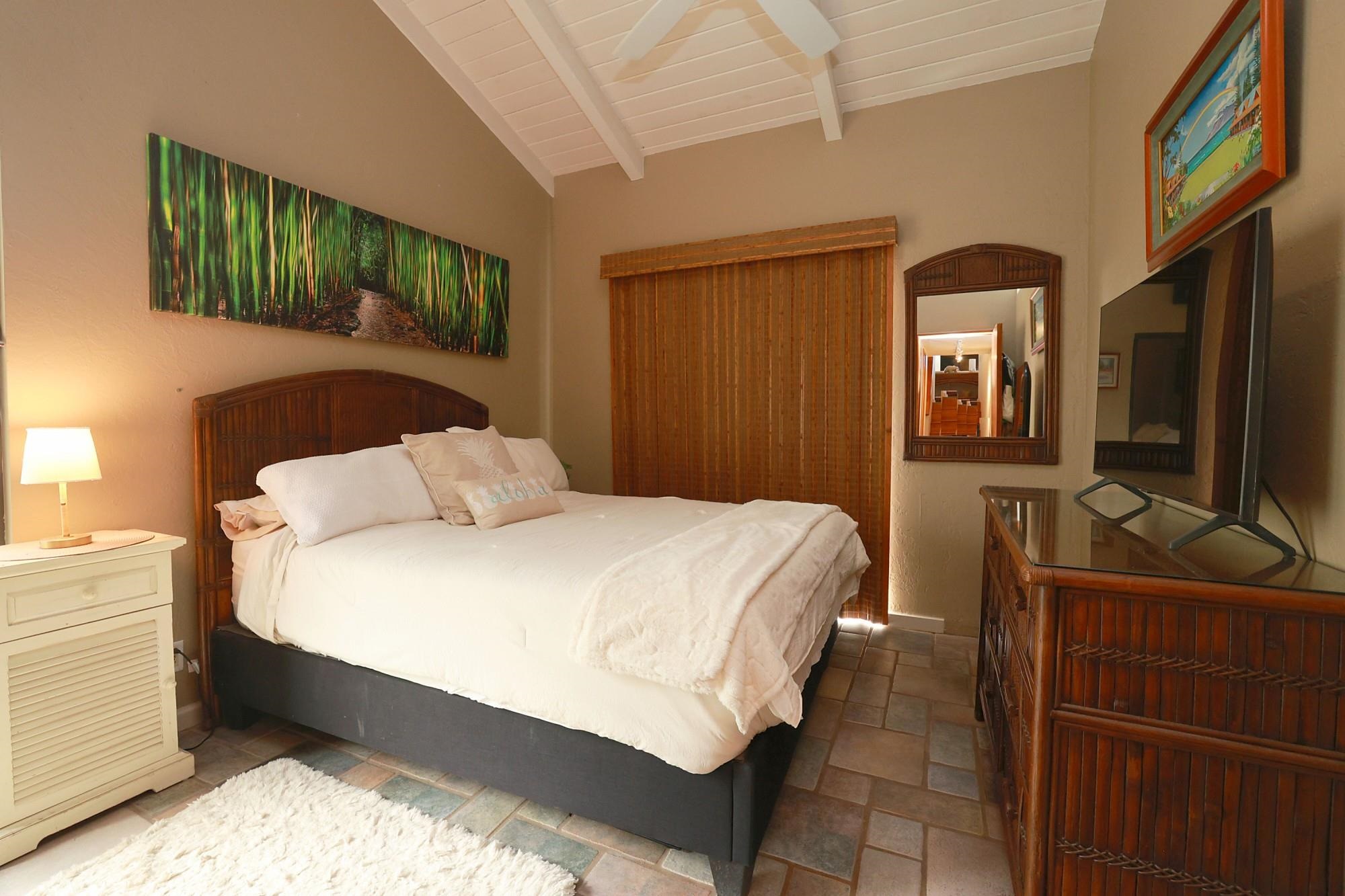 5045 Lower Honoapiilani Road, Unit 2 Lahaina, HI 96761 - Photo 9 of 37 a bedroom with a bed and a flat tv screen on dresser