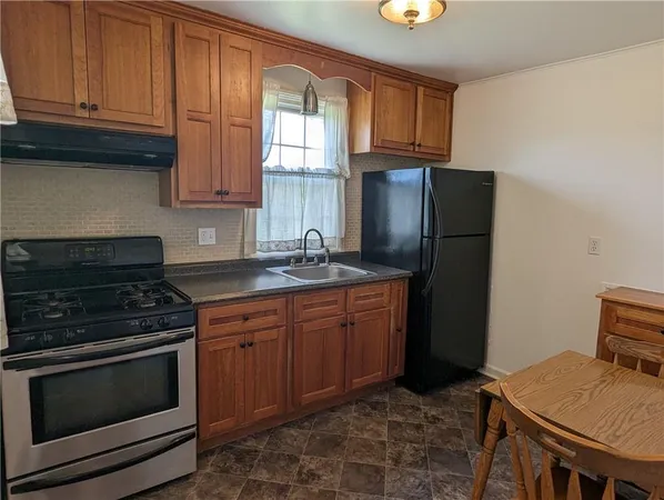 a kitchen with stainless steel appliances granite countertop a stove a refrigerator and a cabinets