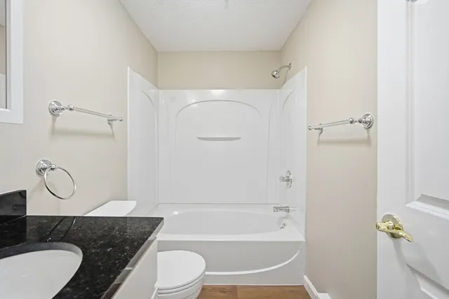 a bathroom with a granite countertop toilet sink and shower