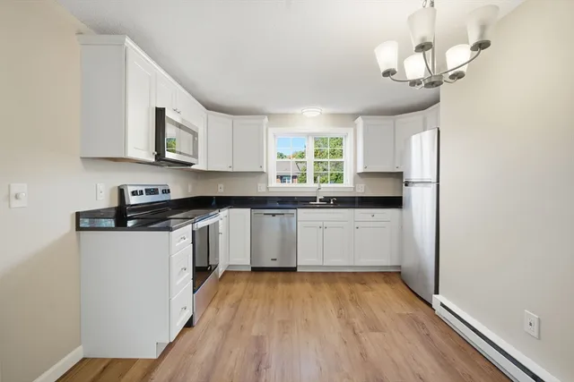 a kitchen with stainless steel appliances granite countertop a sink a stove and refrigerator