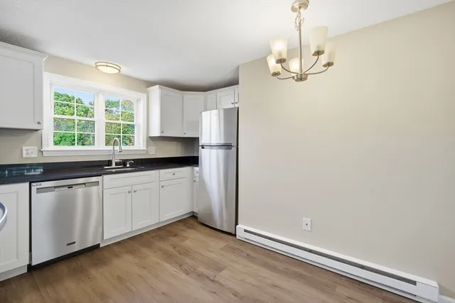 a kitchen with granite countertop cabinets a window and stainless steel appliances
