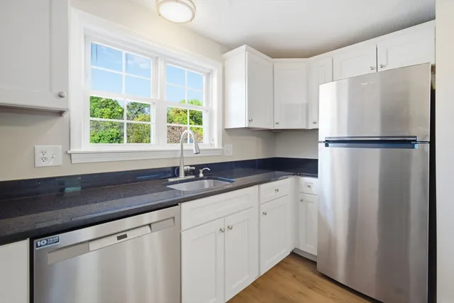 a kitchen with appliances a sink and a window
