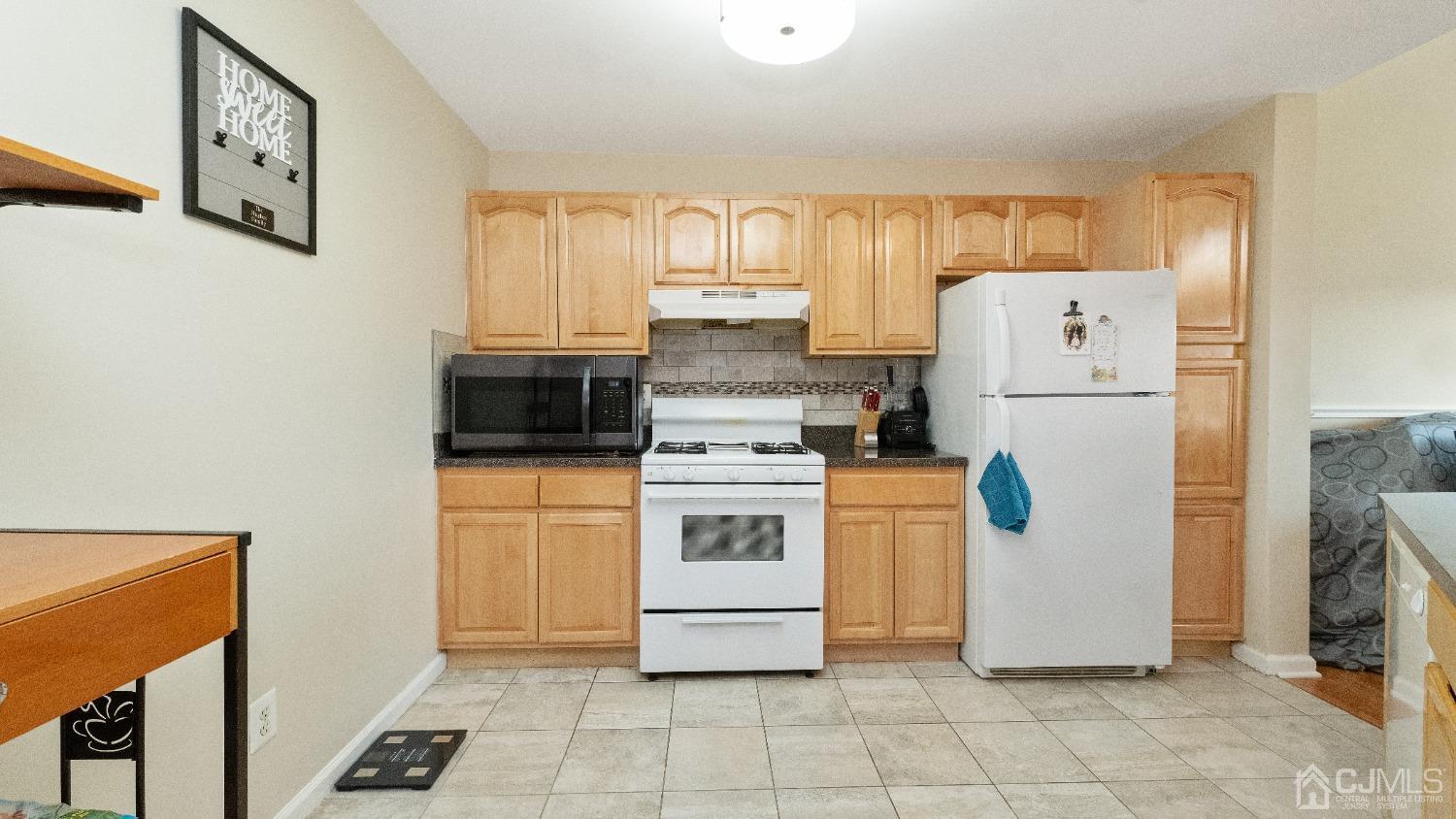 1133 Edpas Road New Brunswick, NJ 08901 - Photo 5 of 26 a kitchen with a refrigerator a stove top oven a counter space and a window