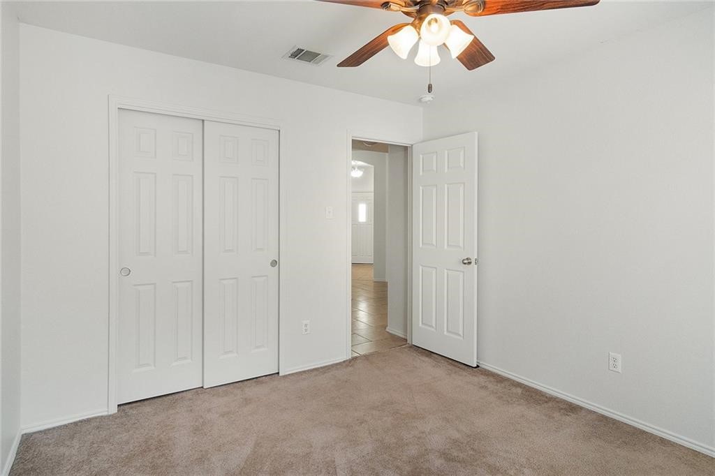 913 Cindy Lane Leander, TX 78641 - Photo 21 of 28 an empty room with a chandelier fan and closet area