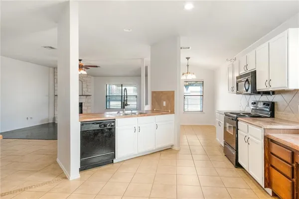 a large kitchen with stainless steel appliances granite countertop a stove and a sink