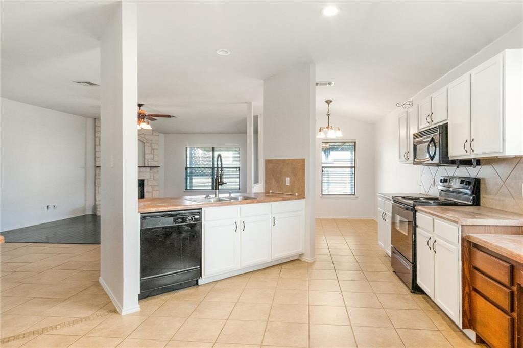 913 Cindy Lane Leander, TX 78641 - Photo 5 of 28 a large kitchen with stainless steel appliances granite countertop a stove and a sink