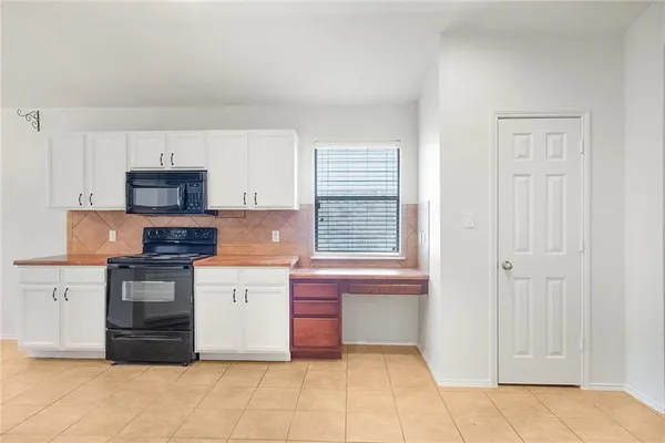 a kitchen with granite countertop white cabinets and stainless steel appliances