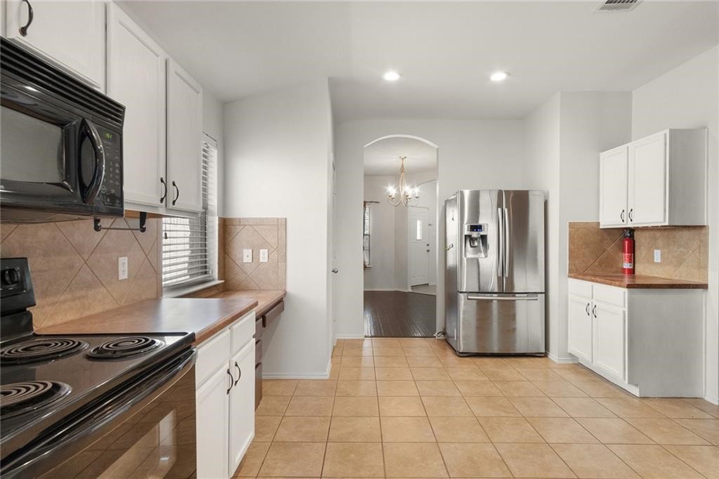 913 Cindy Lane Leander, TX 78641 - Photo 7 of 28 a kitchen with stainless steel appliances granite countertop a refrigerator and a stove