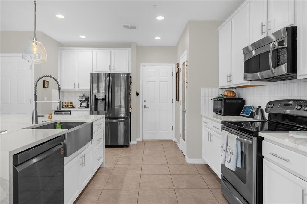 2096 Water Tupelo Way Ocoee, FL 34761 - Photo 12 of 32 a kitchen with a sink stainless steel appliances and cabinets